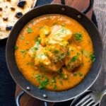 Creamy rich chicken tikka masala curry in an iron karai served with chapati
