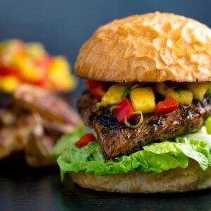 Jamaican jerk chicken burger with a mango salsa & potato wedges