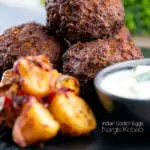 Nargis kebab or Indian Scotch eggs served with Bombay potatoes and cucumber raita featuring a text overlay