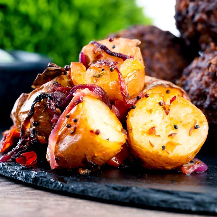 Roast Bombay potatoes or Bombay aloo served on a slate as a side dish