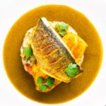 Overhead sea bass fillet curry served with fenugreek potatoes