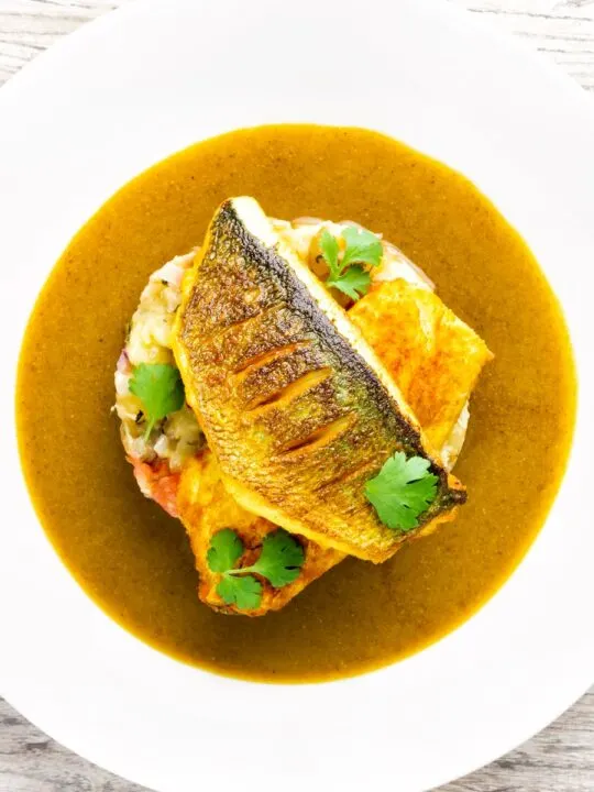 Overhead sea bass fillet curry served with fenugreek potatoes