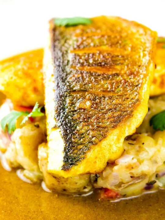 Close up Sea bass curry featuring a tamarind curry sauce & Fenugreek potatoes