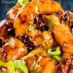 Close up Teriyaki prawns stir fry served on egg fried rice with spring onions with text overlay