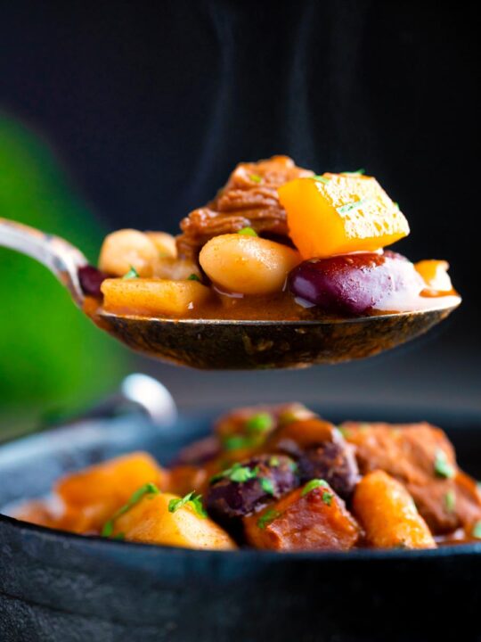 Steaming hot spoonful of Babgulyas, a Hungarian bean goulash taken from an iron bowl.