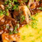 Close up vegan mushroom ragu served with polenta and a parsley garnish