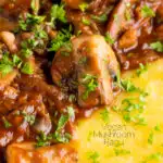 Close up vegan mushroom ragu served with polenta and a parsley garnish featuring a title overlay