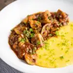 Super Chunky vegan mushroom ragu served with polenta and a parsley garnish