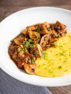 Super Chunky vegan mushroom ragu served with polenta and a parsley garnish