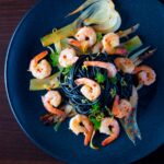 Overhead prawn pasta with squid ink spaghetti fennel and chilli.