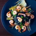 Overhead prawn pasta with squid ink spaghetti fennel and chilli.