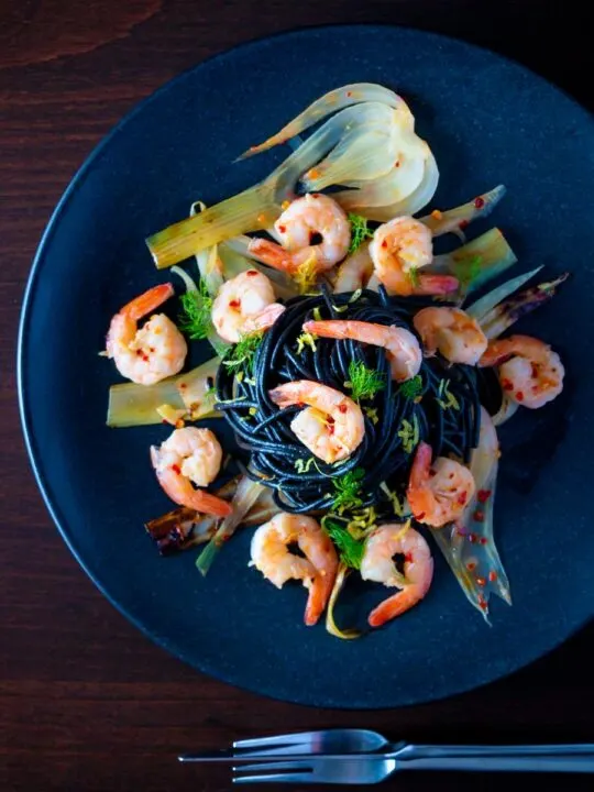 Overhead prawn pasta with squid ink spaghetti fennel and chilli.