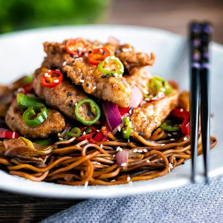 Salt and chilli chicken served with peppers and onion on stir fried soy noodles.