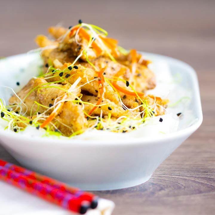 Crispy fried Chinese salt and pepper chicken with shredded chilli and sprouted onion seeds.
