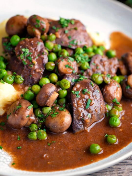 Chicken liver stew with button mushrooms and peas in a red wine sauce.