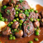 Chicken liver stew with button mushrooms and peas in a red wine sauce featuring a title overlay.