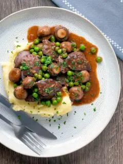 Chicken liver stew with button mushrooms and peas in red wine sauce served with mashed potato.