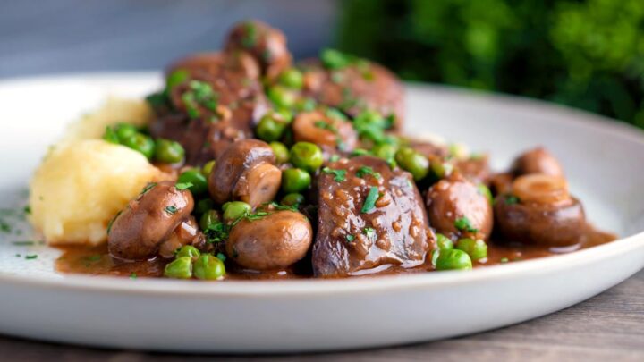 Chicken liver stew with button mushrooms and peas in red wine sauce served with mash.