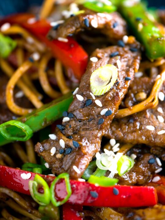 Close up Szechuan beef stir fry with noodles and bell peppers.