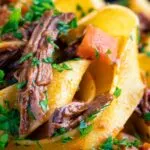 Close up rich venison ragu sauce served with pappardelle pasta.