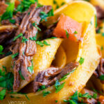 Close up rich venison ragu sauce served with pappardelle pasta featuring a title overlay.