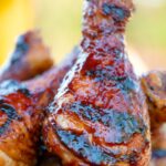 Close up bbq chicken drumsticks with a beer, paprika and honey glaze.
