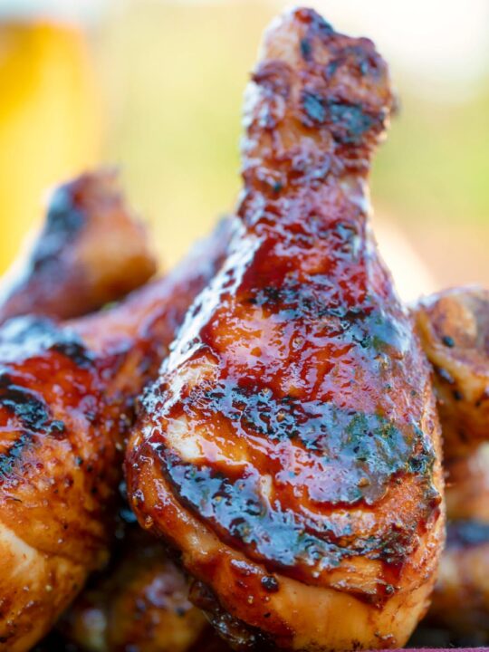 Close up bbq chicken drumsticks with a beer, paprika and honey glaze.