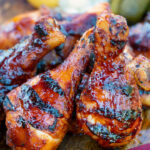 BBQ chicken drumsticks with a beer, paprika and honey glaze featuring a title overlay.