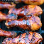 BBQ chicken drumsticks with a beer, paprika and honey glaze cooking on the grill featuring a title overlay.