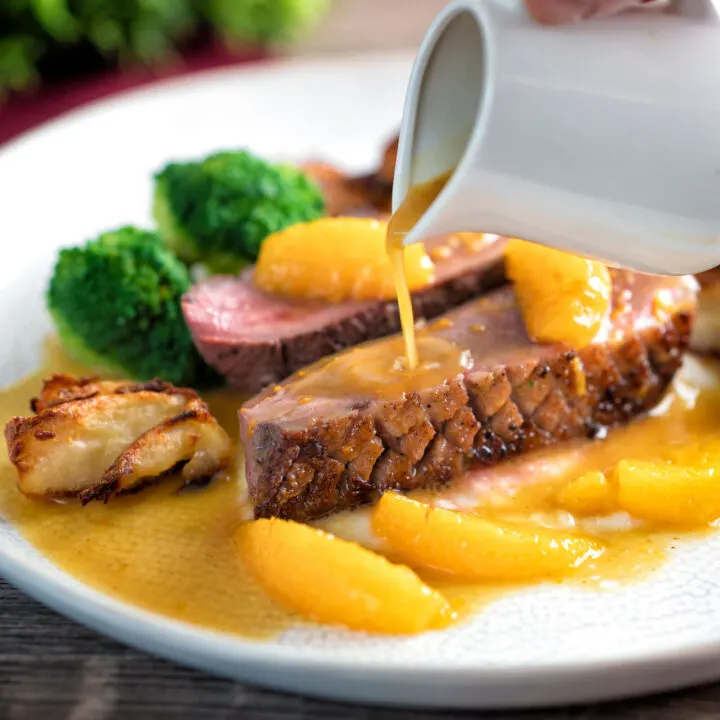 Orange sauce poured over a rosy pan fried duck breast with crispy skin.