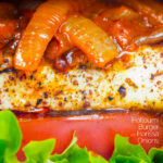 Close up Halloumi burger with harissa onions, tomato & lettuce featuring a title overlay.