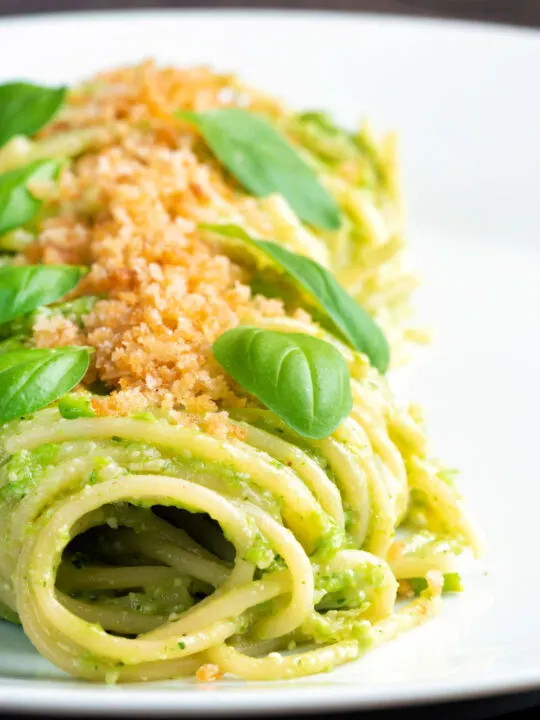 Peas pesto served as a sauce for pasta with a breadcrumb crust.