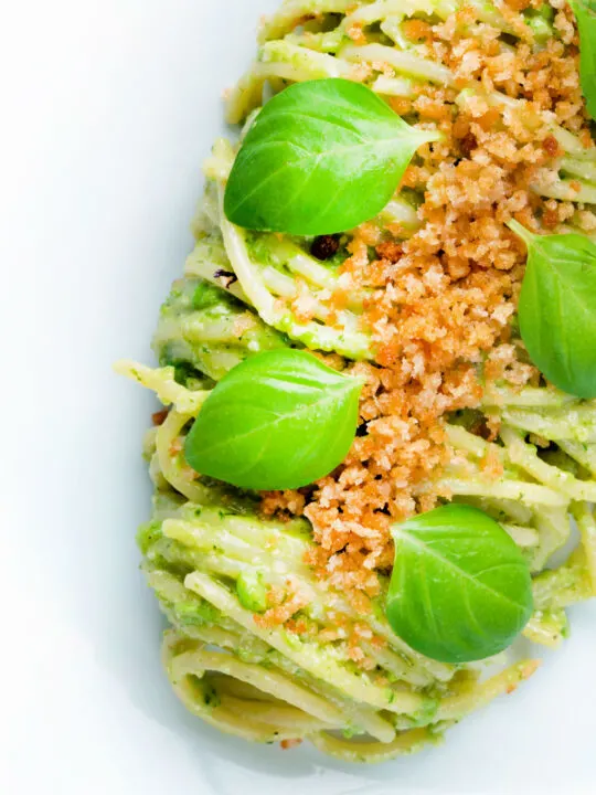 Overhead pea pesto served as a sauce for pasta with a breadcrumb crust.
