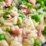 Close up pea and ham risotto served in a blue bowl featuring a title overlay.