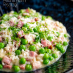 Pea and ham risotto served in a blue bowl garnished with goats cheese and parsley featuring a title overlay.