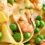 Close up prawn and peas pasta with pappardelle and shredded basil.