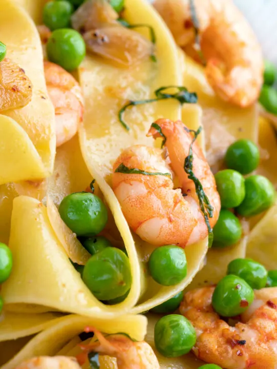 Close up prawn and peas pasta with pappardelle and shredded basil.