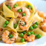 Prawn and pea pasta with pappardelle and shredded basil featuring a title overlay.