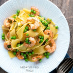 Overhead prawn and pea pasta with pappardelle served in a textured bowl featuring a title overlay.