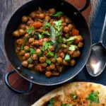 Overhead vegan Punjabi chole masala curry served in an iron karai.
