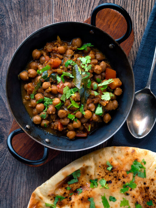 Overhead vegan Punjabi chole masala curry served in an iron karai.