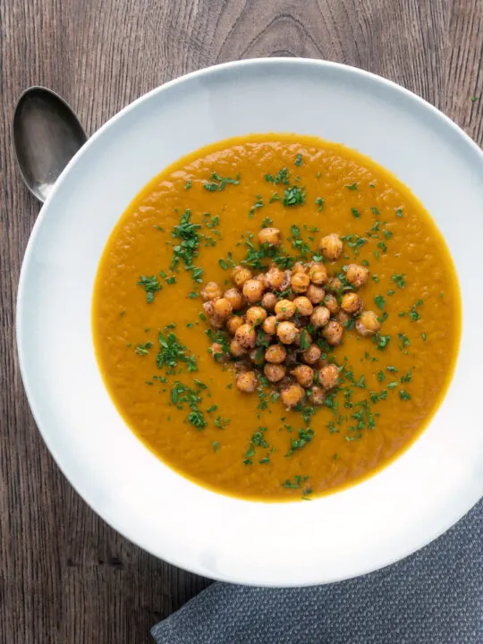 Overhead vegan roasted carrot soup with crispy chickpeas.