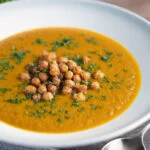 Spicy vegan roasted carrot soup with crispy chickpeas.