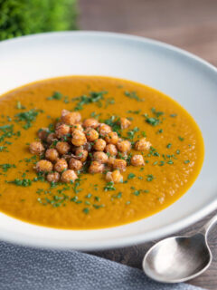 Spicy vegan roasted carrot soup with crispy chickpeas.