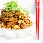 Szechuan chicken with cashew nuts and spring onion served on white rice.