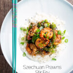 Overhead Szechuan prawns with green pepper served on steamed rice in a white bowl featuring a title overlay.