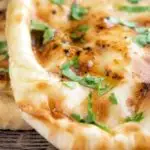 Close up British Indian Curry house style Tandoori naan bread with coriander.