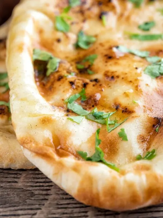 Close up British Indian Curry house style Tandoori naan bread with coriander.