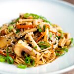Vegetarian mushroom chow mein noodles served with shredded spring onion.
