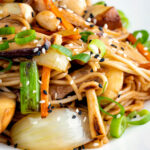 Close up vegetarian mushroom chow mein noodles using 3 types of mushroom featuring a title overlay.